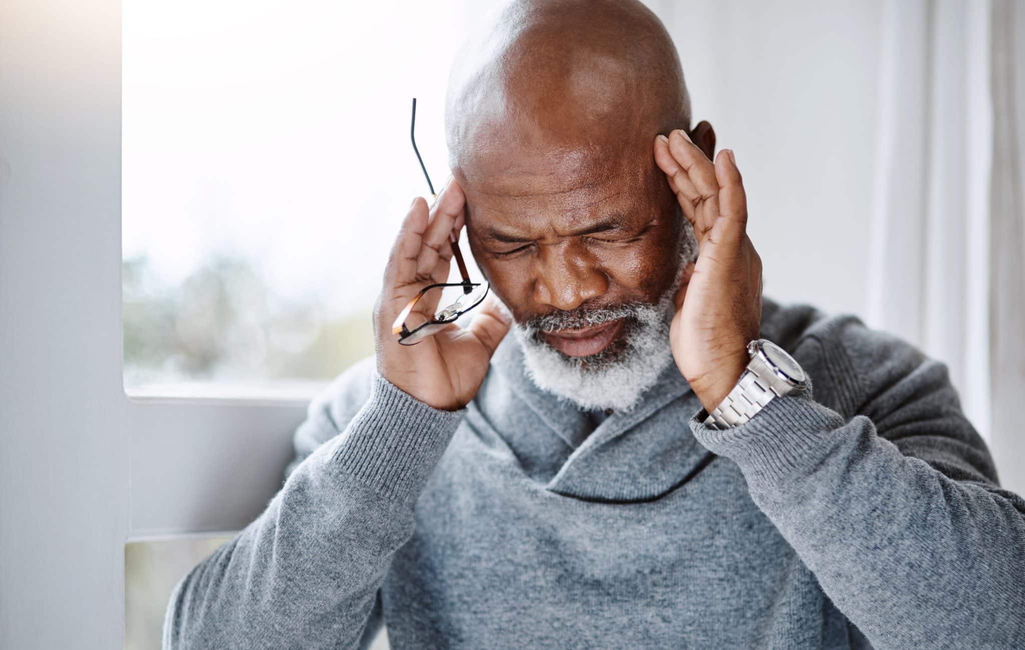 Senior man experiencing a headache.